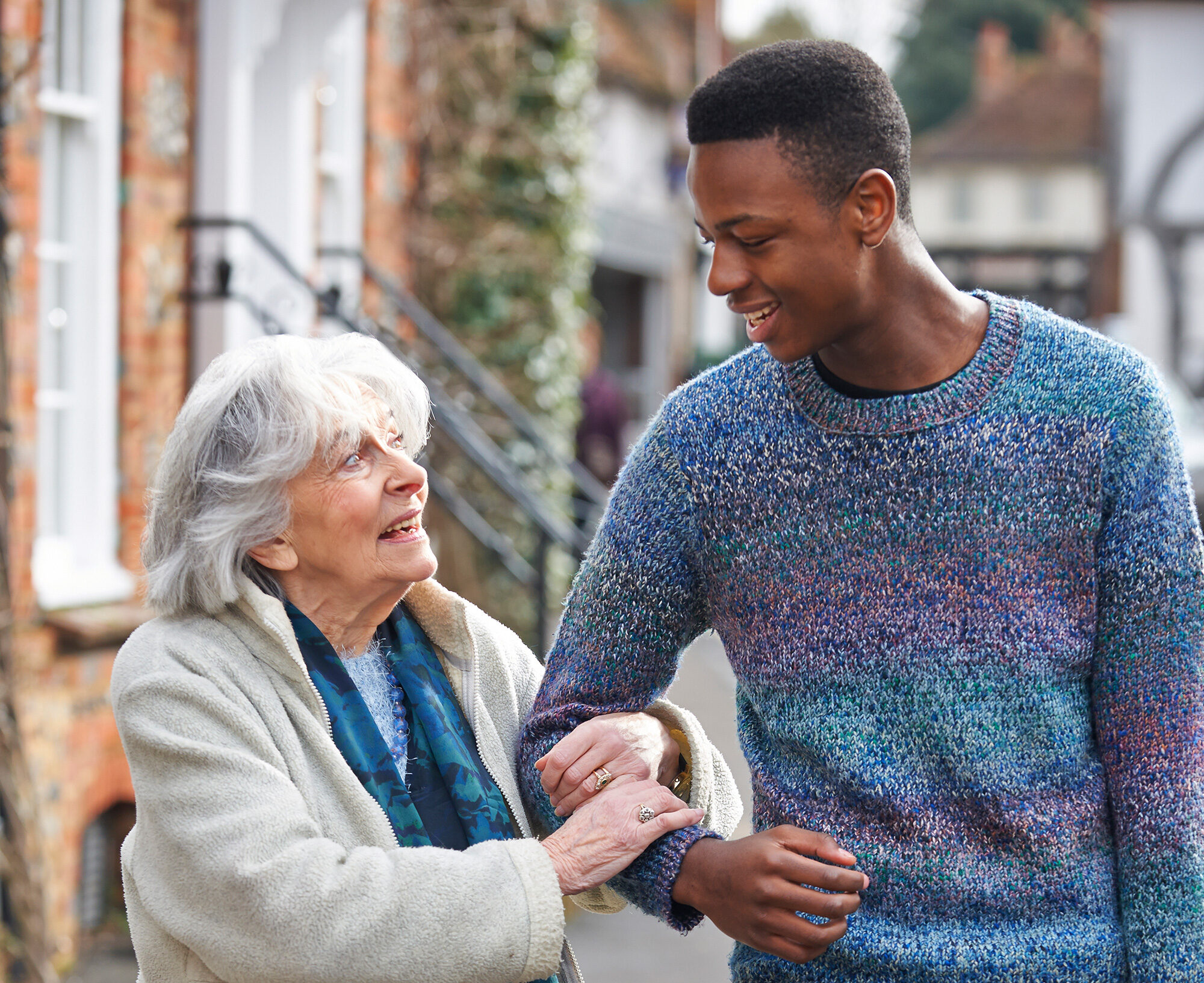A man walking with an older woman on the street