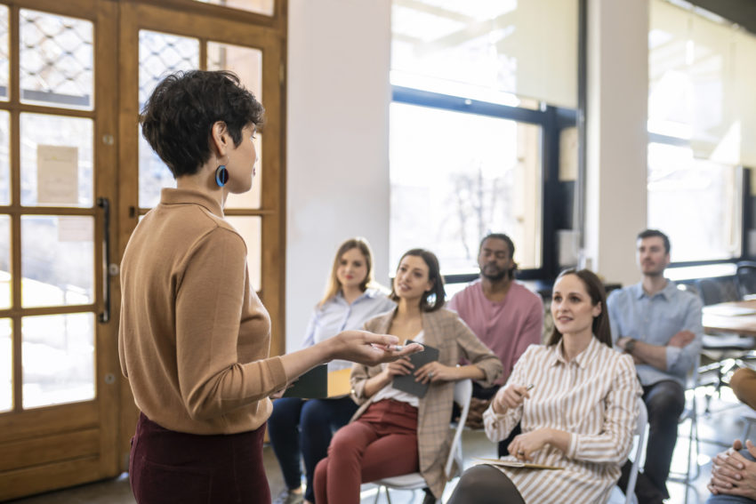 Group of people in the class listening a professor